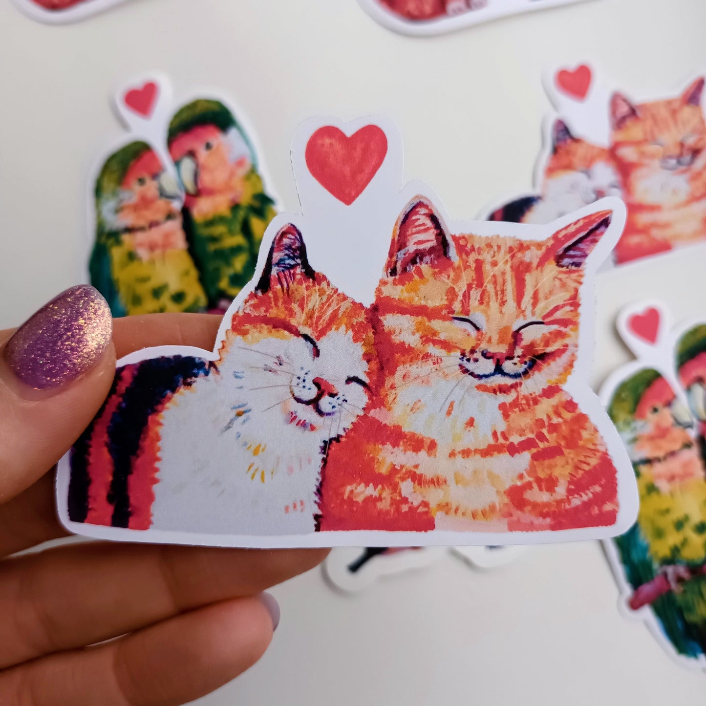 Romantic cats in love sticker, close-up hand-drawn illustration, waterproof vinyl decal held by hand