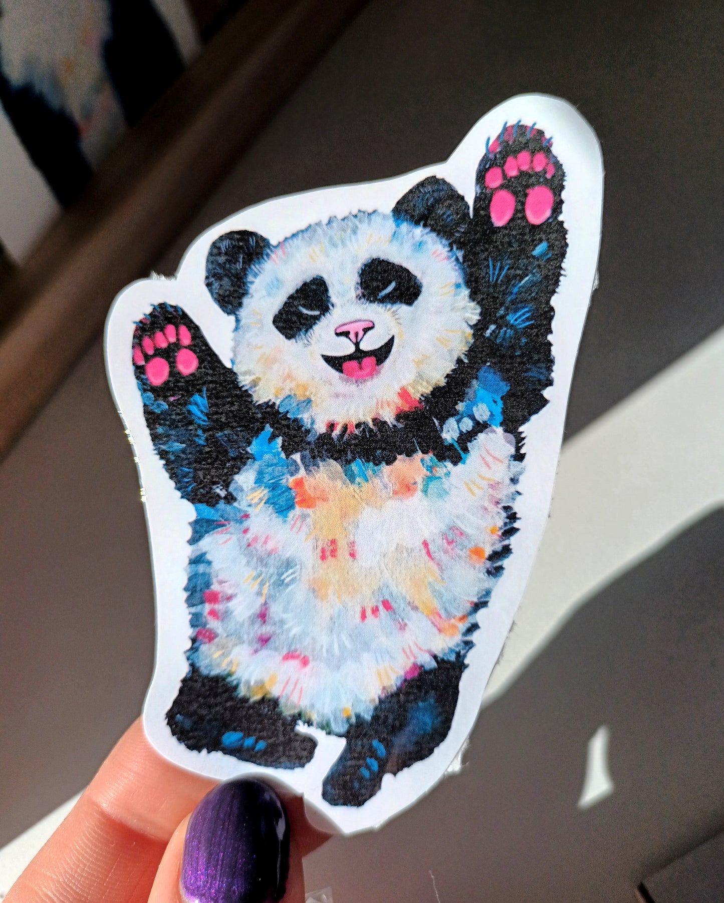 Cute colorful happy panda sticker, hand-drawn design on waterproof vinyl, perfect for decorating laptops and water bottles held by hand.