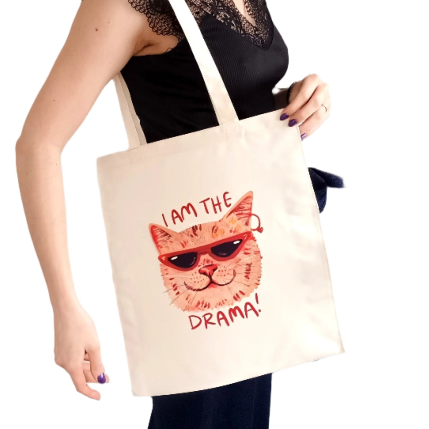 Double-sided tote bag featuring a funny dramatic cat. One side says "Am I the Drama?" while the other says "I Am the Drama". Printed on durable, waterproof polyester. Perfect for cat lovers and drama queens.