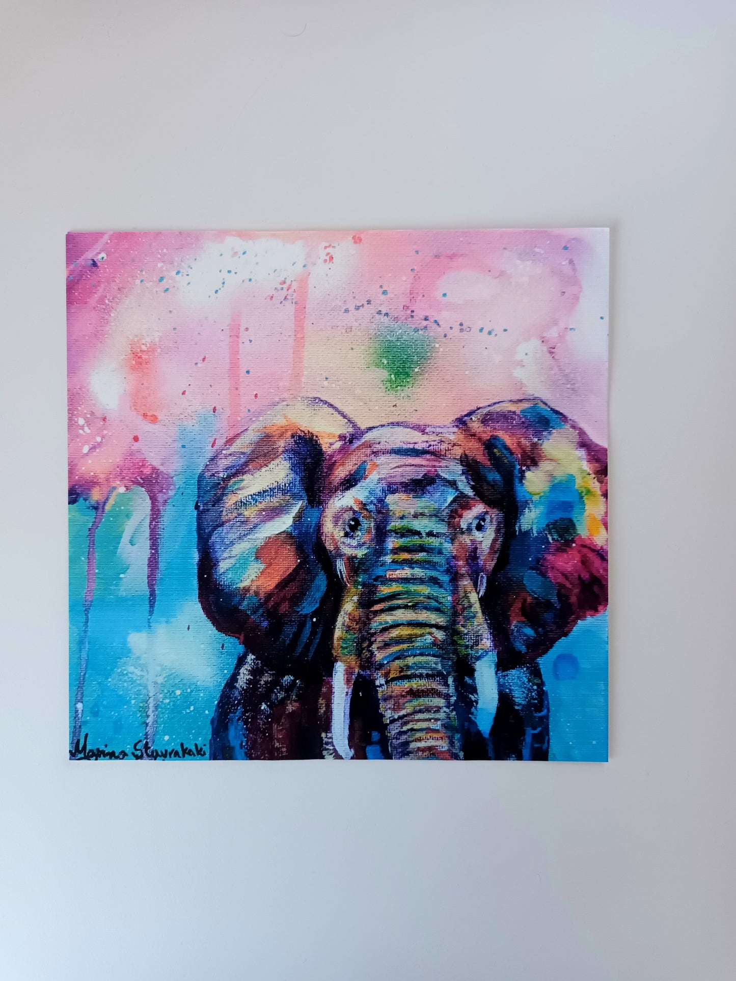 Art print of a magical elephant with colourful spray paint background on a table, printed on eco-friendly matte paper.