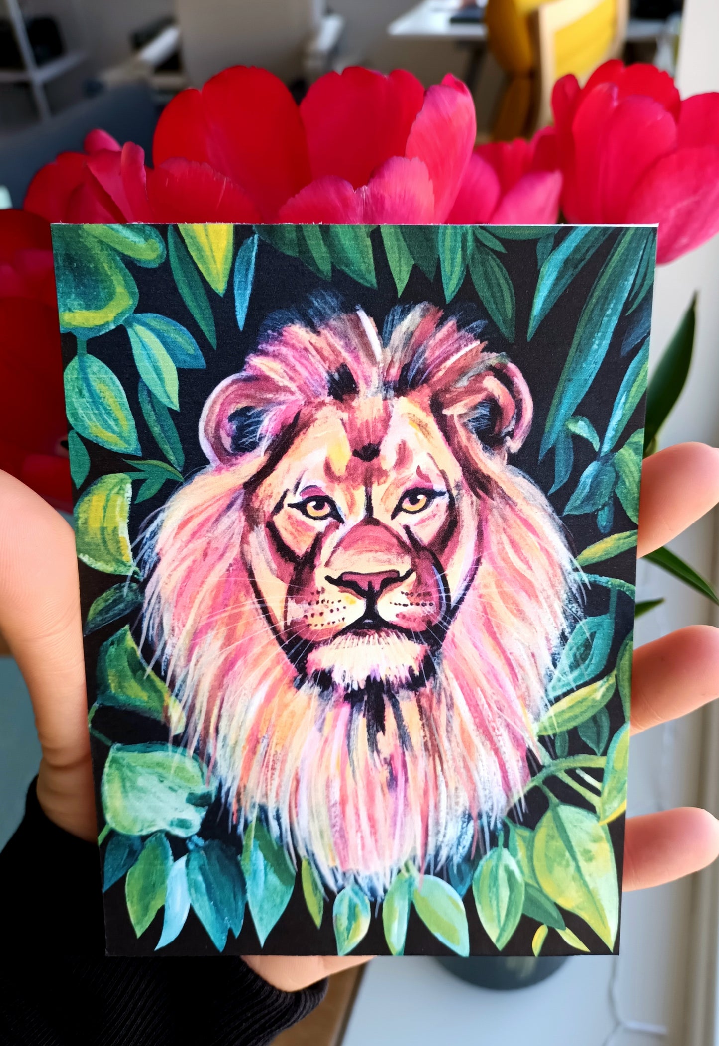 Colourful postcard illustration of a lion surrounded by green jungle leaves, printed on eco-friendly paper help by hand.