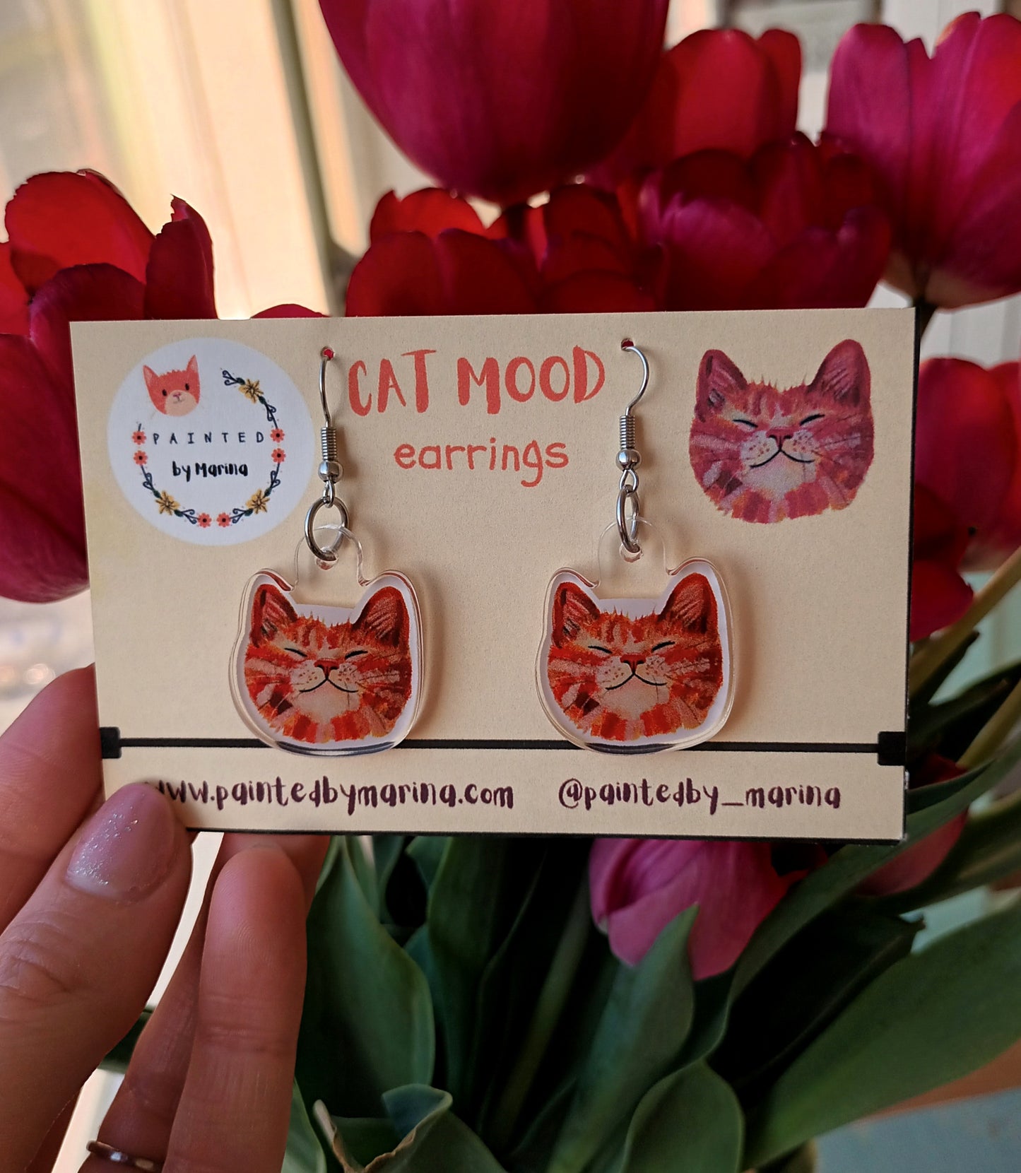 Cute handmade earrings with smiling orange cat faces.