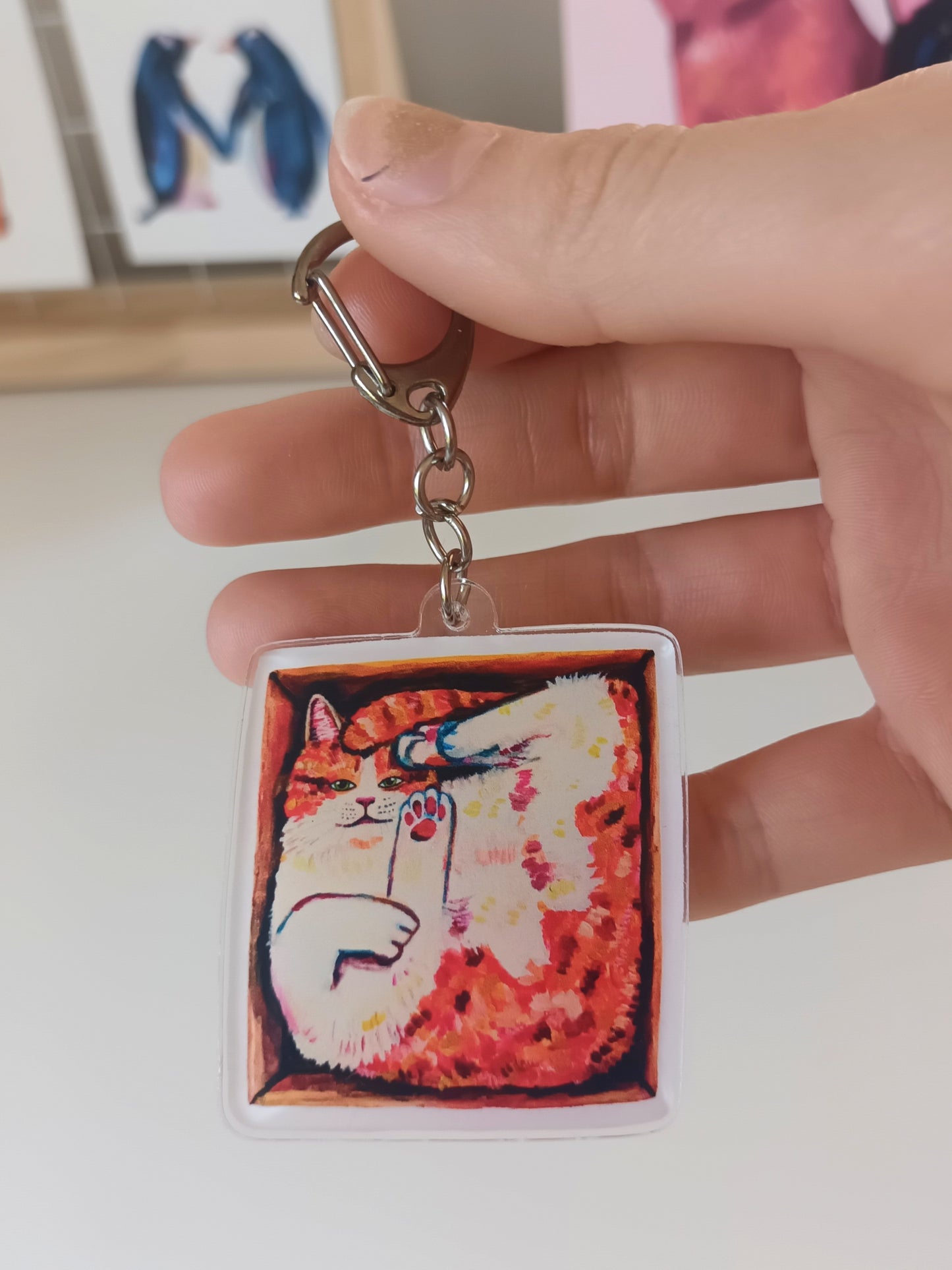 Handmade acrylic keychain with an illustrated orange cat in a box, stainless steel ring.