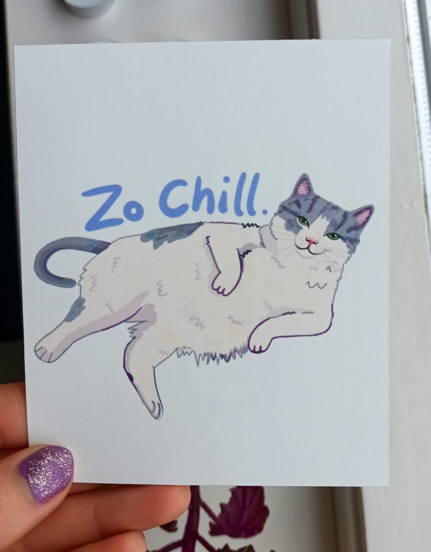 Lazy hand-painted cat lounging with a sassy expression, printed on a matte, slightly square eco-friendly postcard held by hand