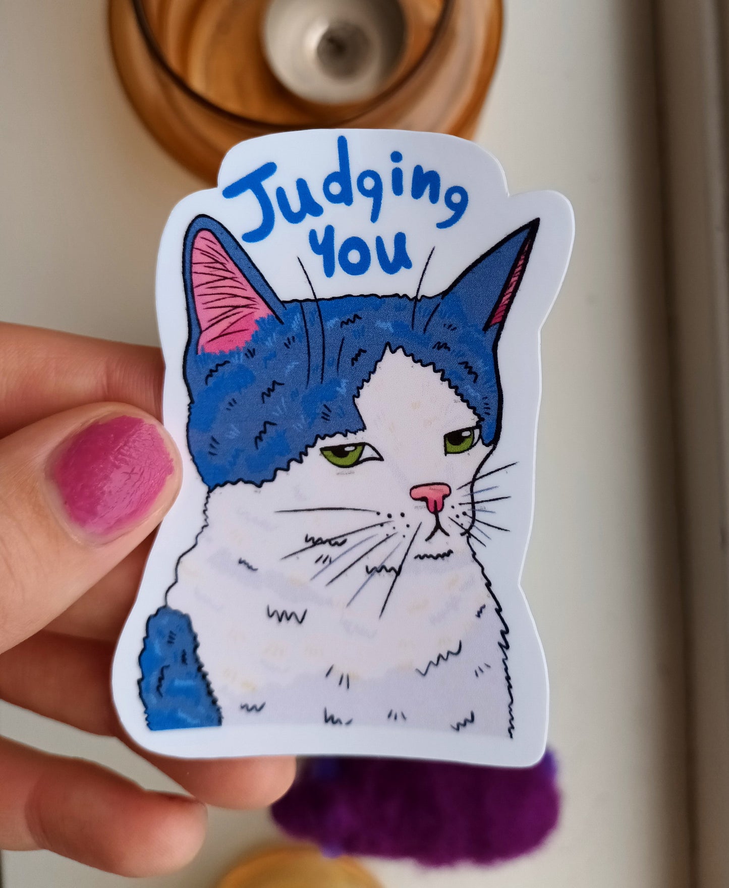 Vinyl sticker of a tuxedo cat with a judging expression