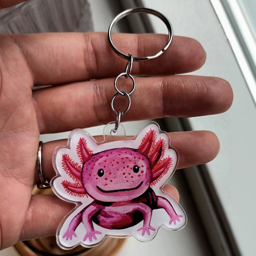 Acrylic keychain with a cute pink axolotl design, attached to a stainless steel key ring. Approx. 5 x 5 cm.