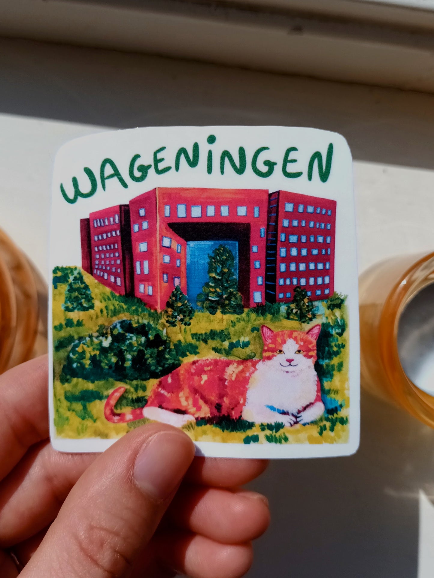 Wageningen sticker with cute orange cat in front of Forum building
