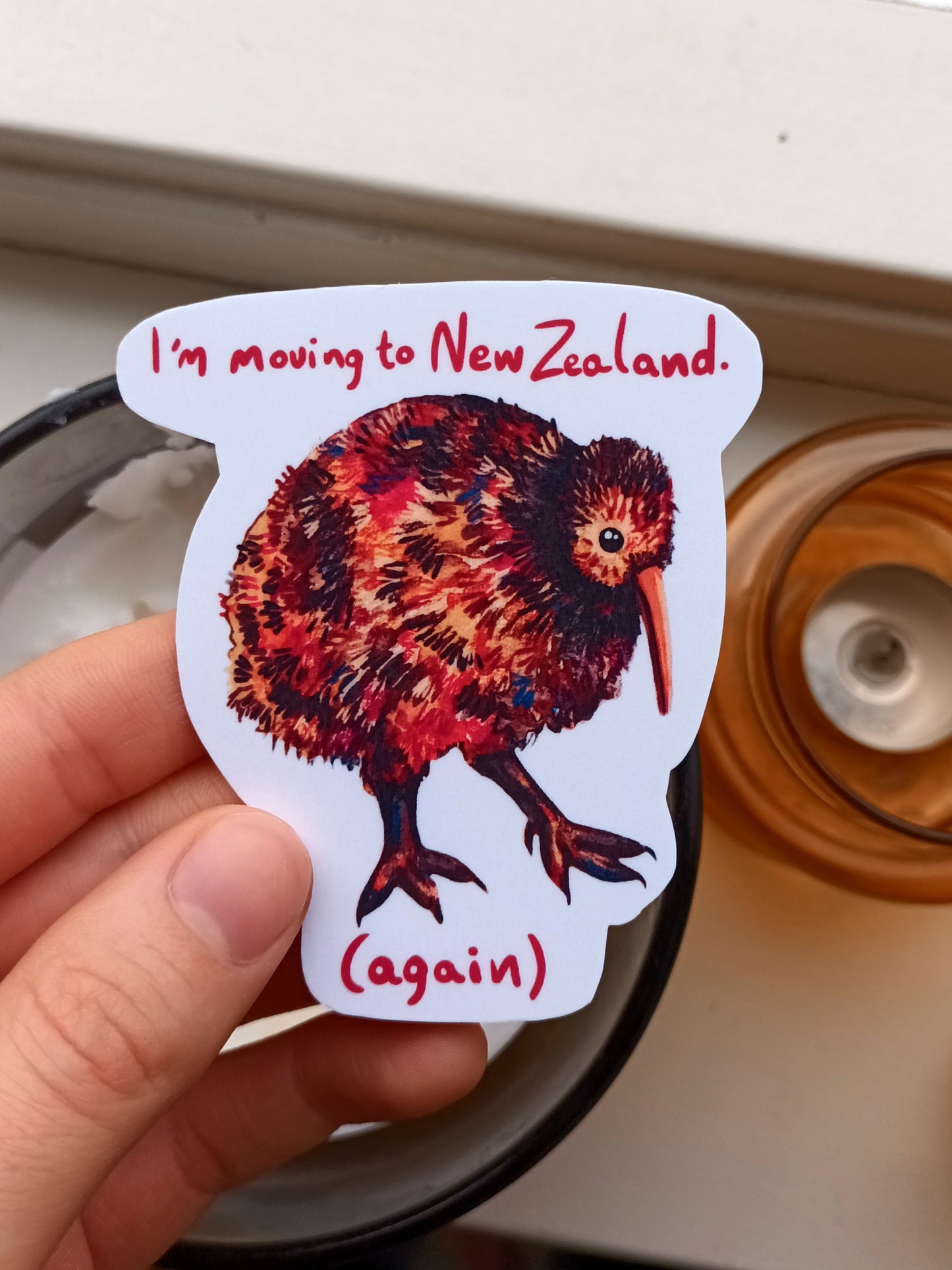 Moving Kiwi sticker with “I’m moving to New Zealand (again)” text, original illustration by the artist, 7 x 8 cm