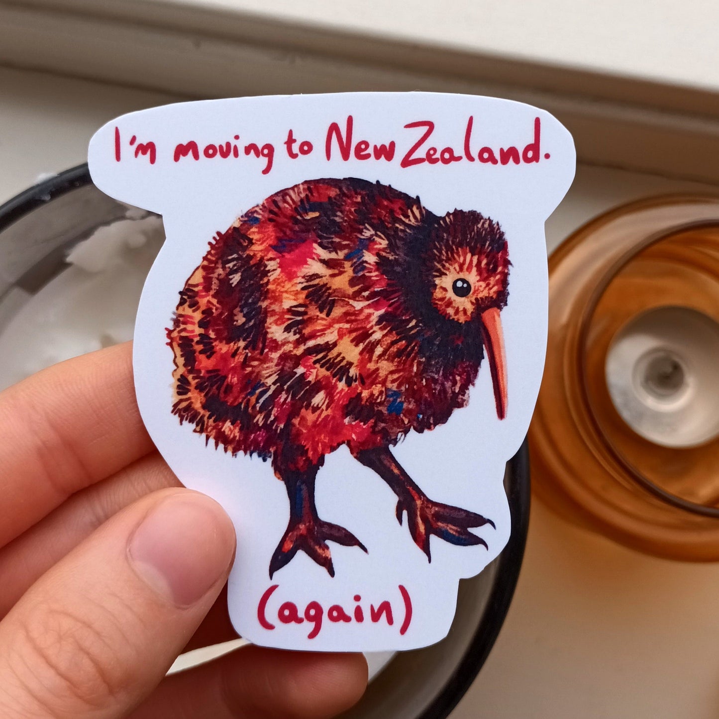 Kiwi sticker with “I’m moving to New Zealand (again)” text, original illustration by the artist, 7 x 8 cm