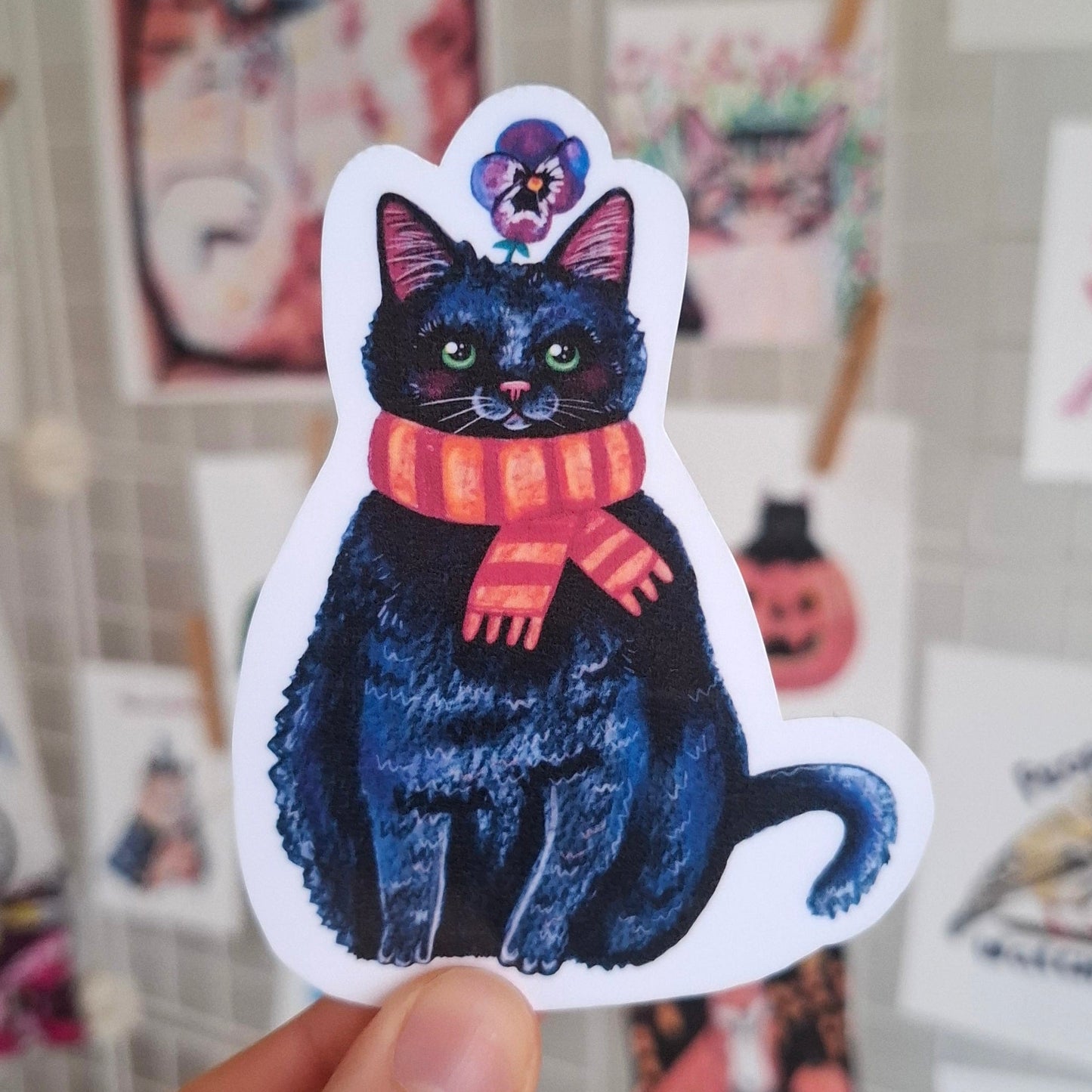 Cute black cat wearing an orange scarf sticker.