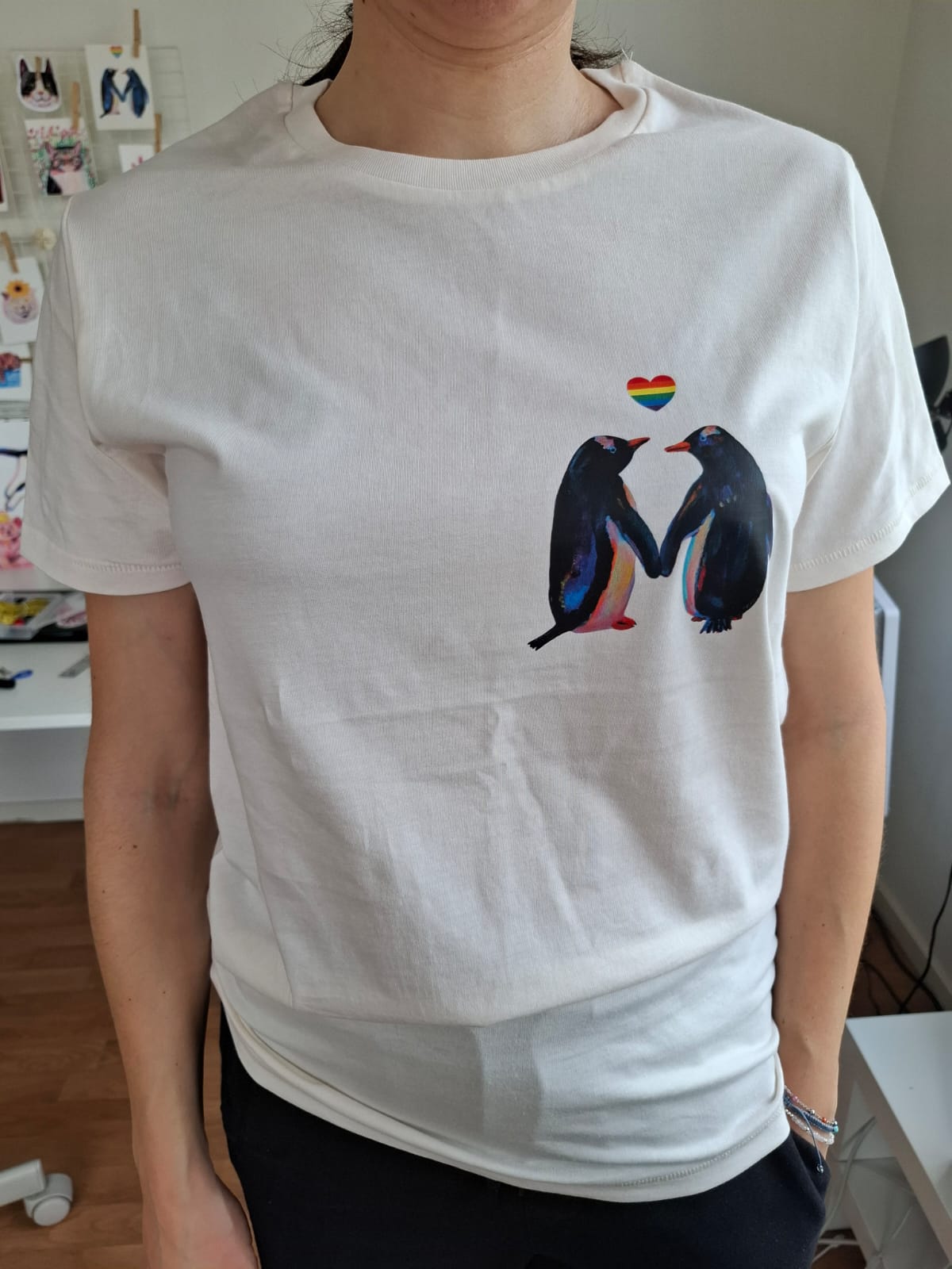 Vintage white organic cotton T-shirt with penguins and rainbow heart printed on the right pocket.