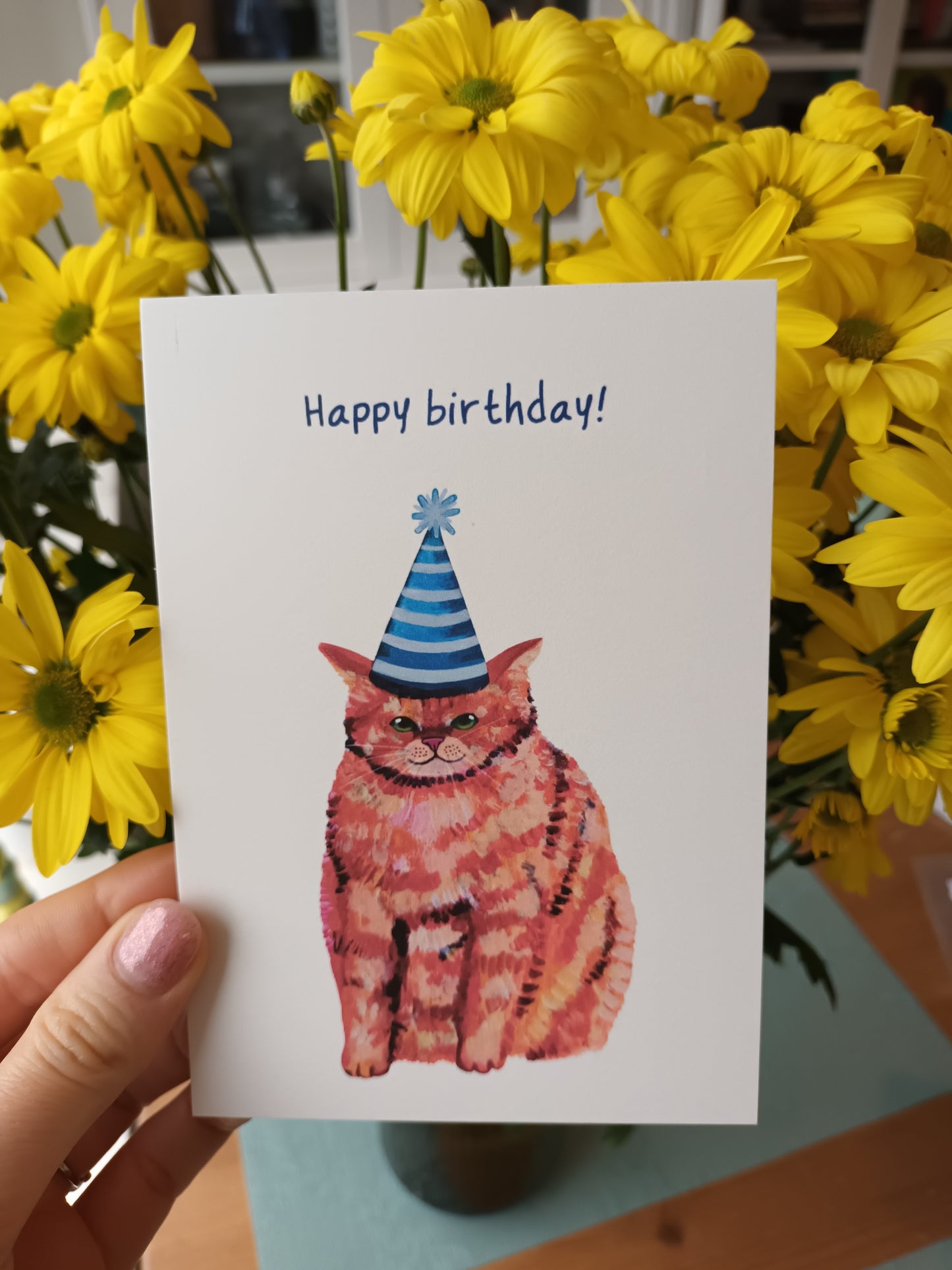 Handmade Happy Birthday greeting card featuring a cute chubby orange cat, high-quality illustration on eco-friendly paper held by hand