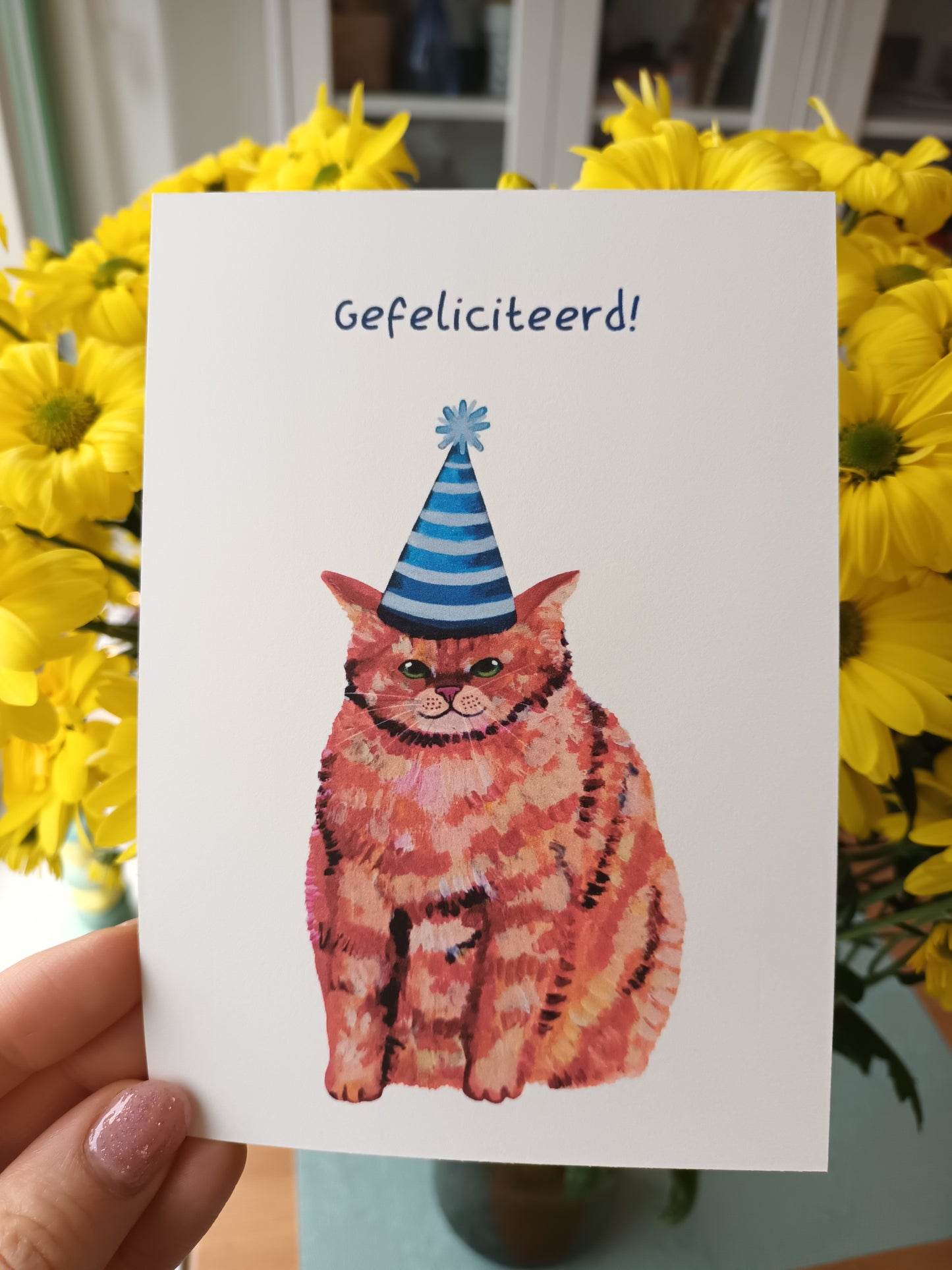 Handmade Happy Birthday greeting card featuring a cute chubby orange cat, high-quality illustration on eco-friendly paper in dutch held by hand