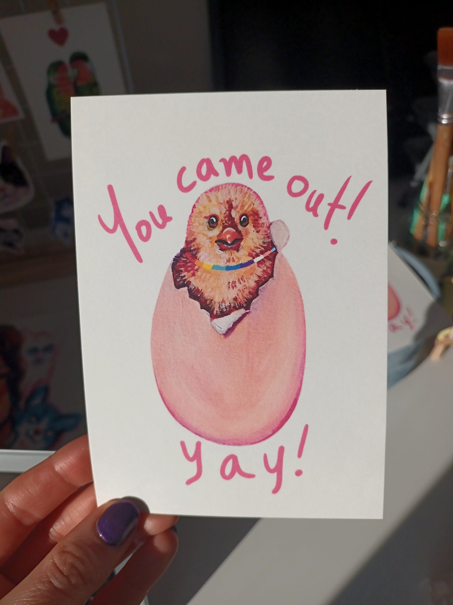 Handmade greeting card featuring a cute chicken coming out of its shell with the message 'You Came Out Yay!', celebrating LGBTQ+ coming outs, printed on eco-friendly paper held by hand.