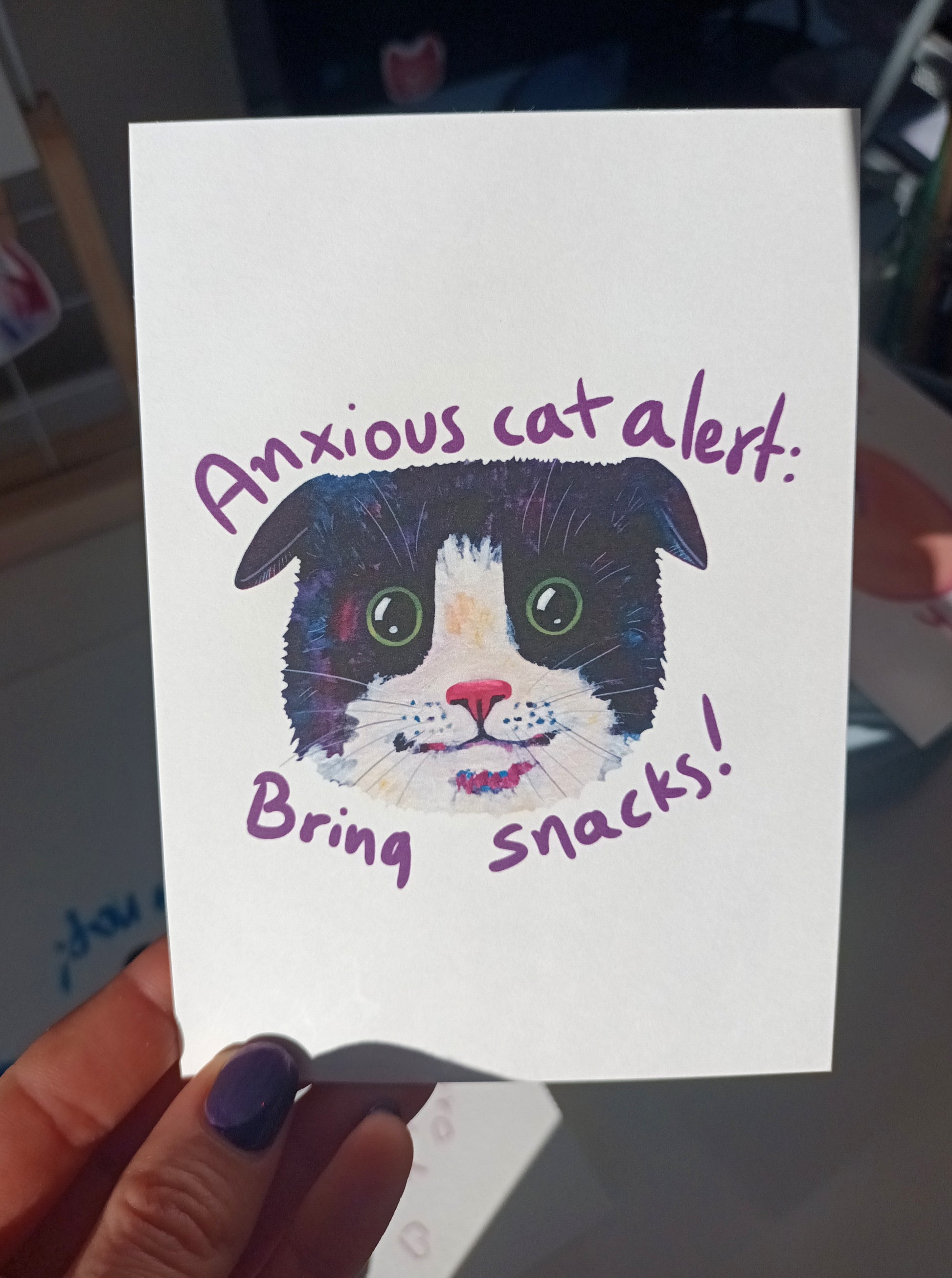 Handmade anxious cat postcard with the text 'Bring Snacks', printed on eco-friendly matte paper, perfect for mailing or collecting held by hand.