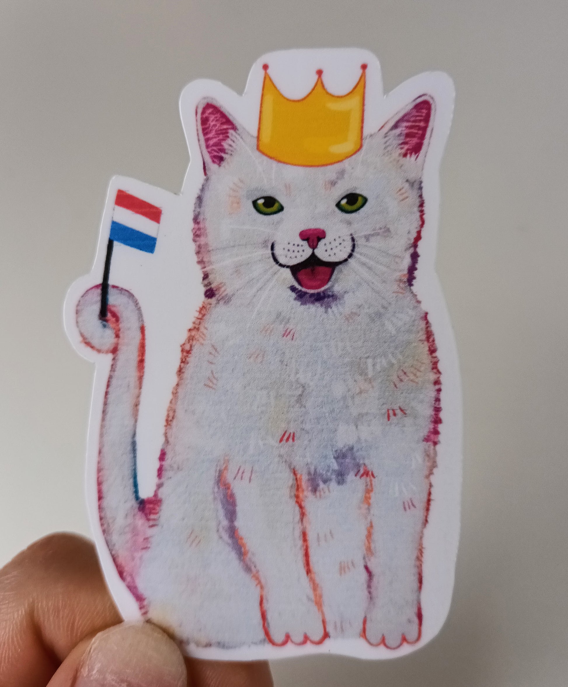Cute waterproof vinyl sticker of a cat wearing a golden crown for King’s Day (Koningsdag), hand-painted and festive held by hand.