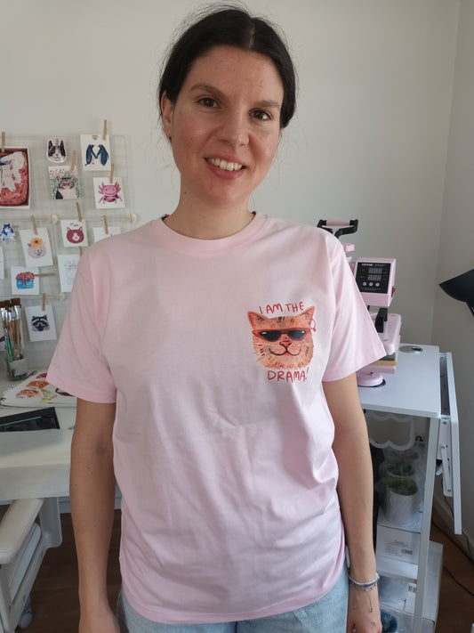 Person wearing I Am the Drama T-shirt in baby pink, made from 100% organic cotton & Fair Trade. 