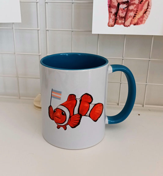 Cute clownfish holding transgender pride flag on handmade mug with blue handle