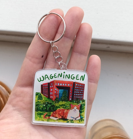 Acrylic Wageningen keychain with orange cat in front of Forum