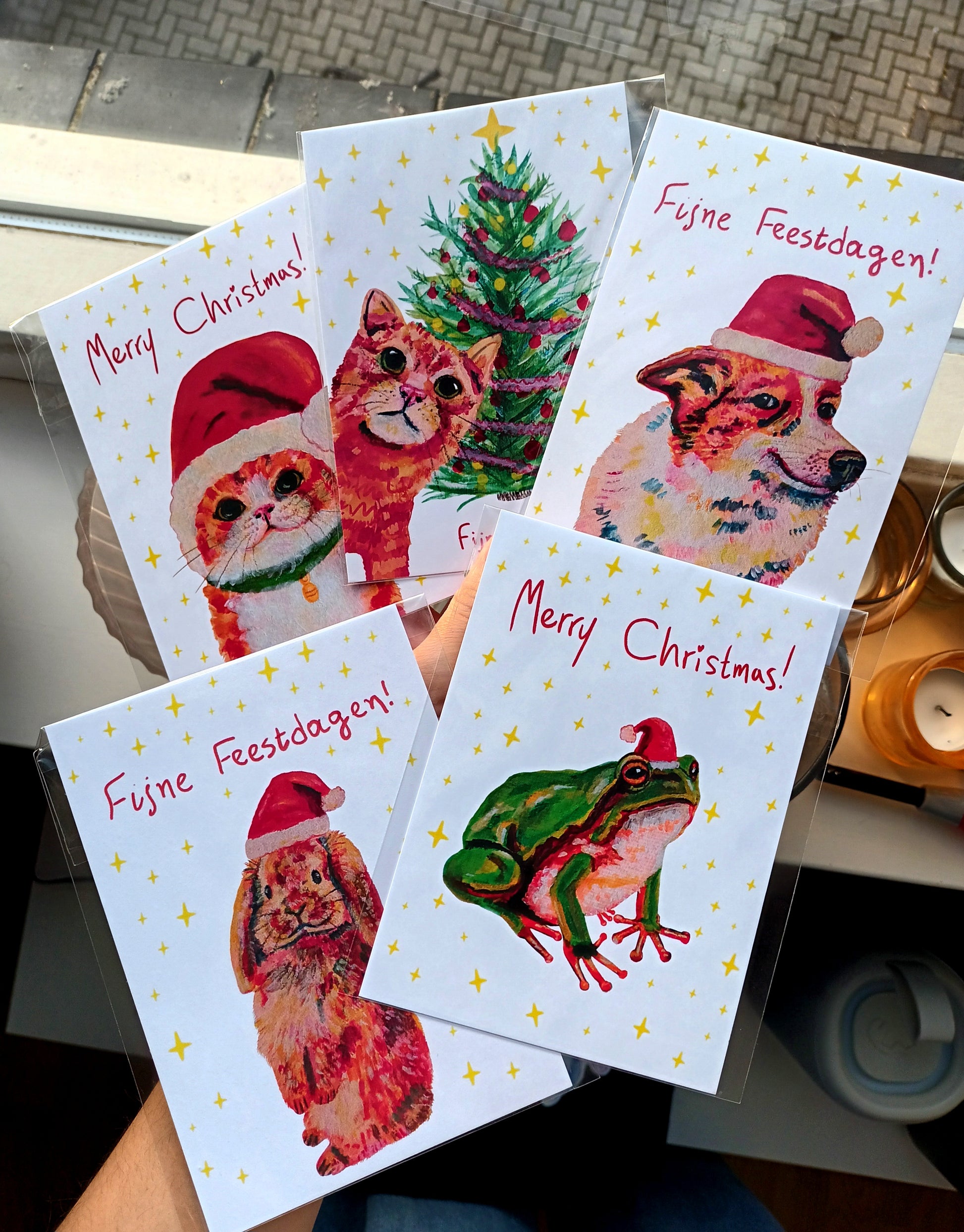 set of Christmas Cards with cute animals with Christmas hats, including cats, a dog, a bunny and a frog.