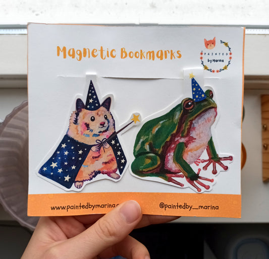 Magnetic bookmarks with a hamster wizard and frog design on a branded card.