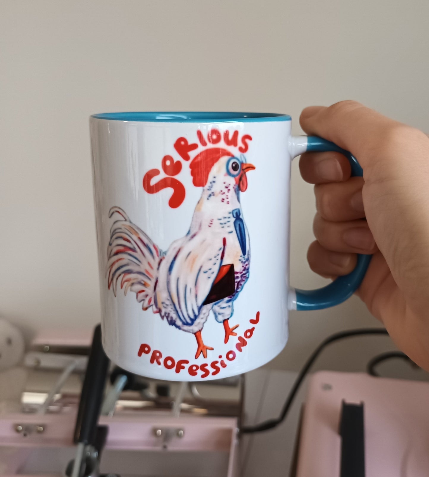 Pip the Professional Chicken mug with blue handle and interior, “Serious Professional” illustration by the artist