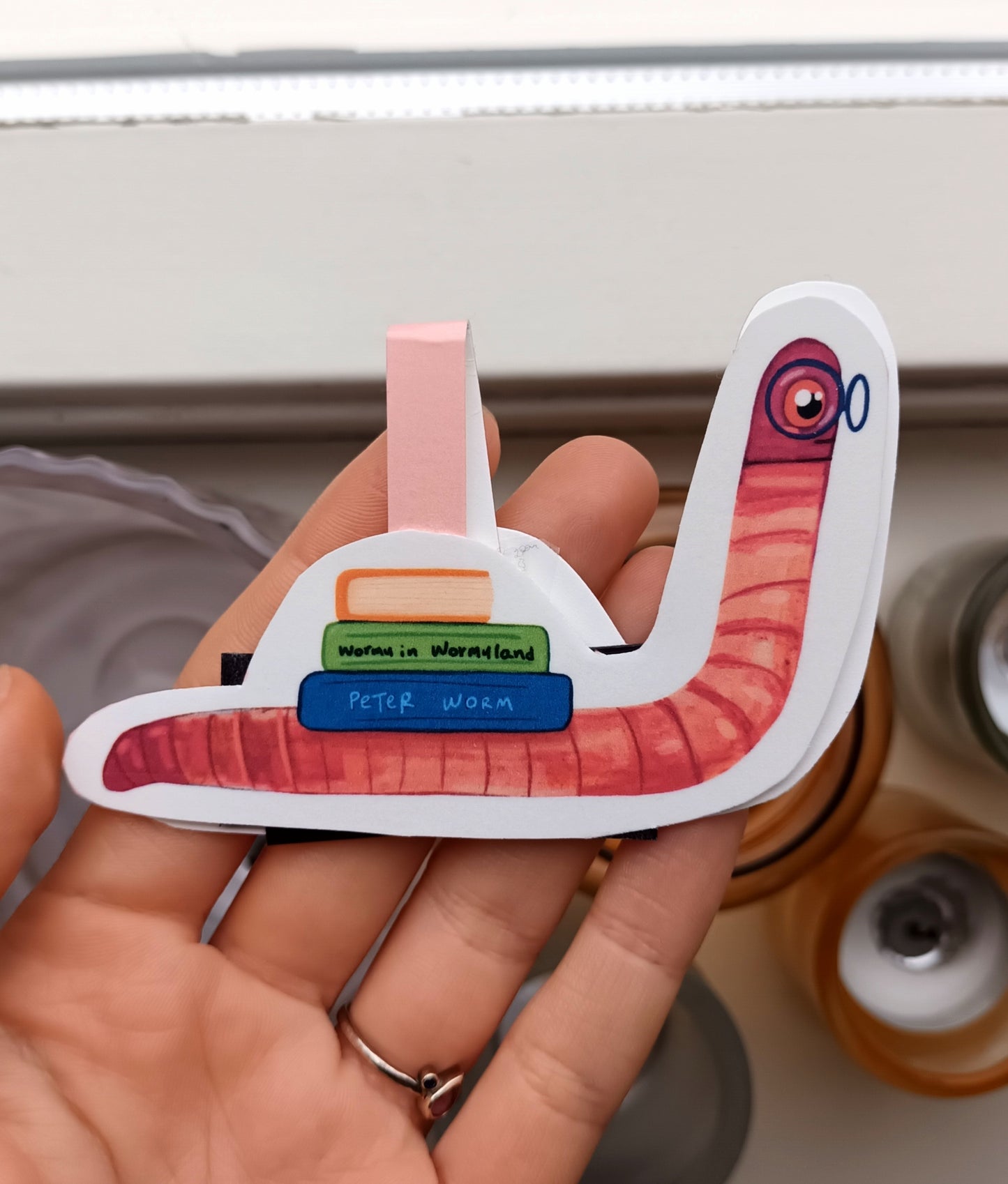 Magnetic bookmark with cute book worm wearing glasses carrying books, original illustration