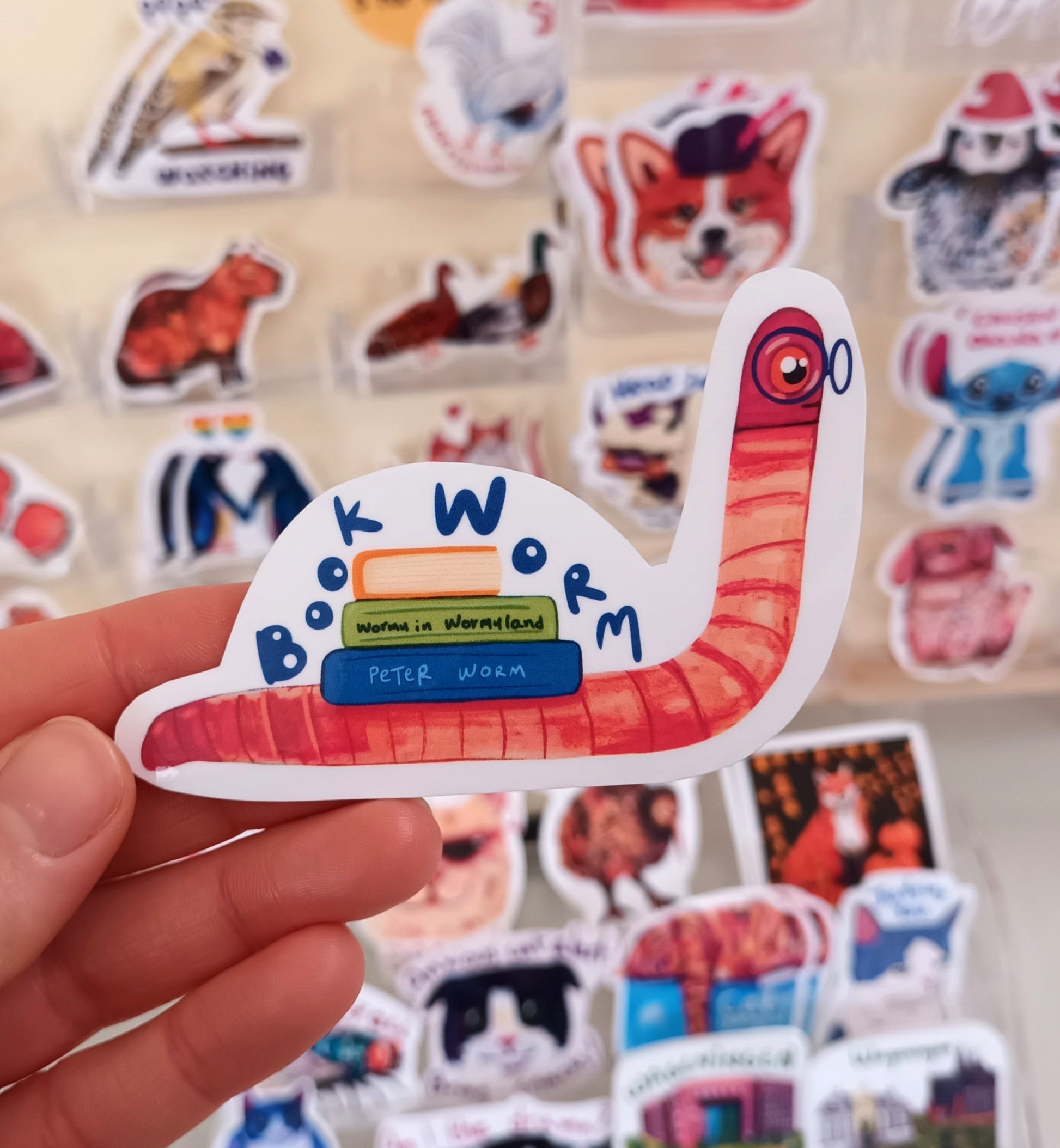 Cute book worm sticker with glasses and books on its back, original illustration