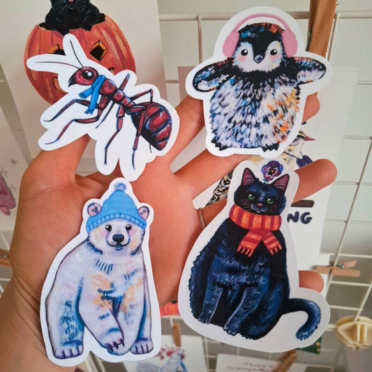 winter collection of four handmade stickers, including a penguin, an ant, a polar bear and a cat with a scarf.