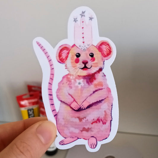 Hand holding a pink mouse sticker who is a witch.