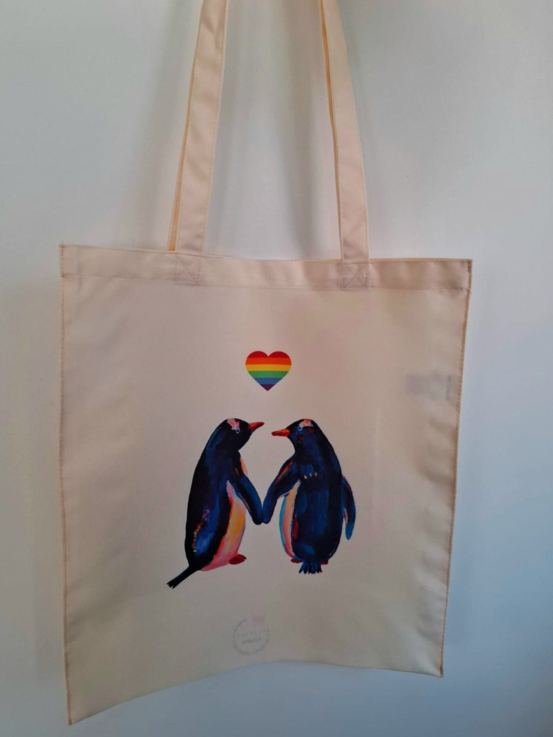 Penguins in Love tote bag featuring a hand-painted design of two affectionate penguins, celebrating LGBTQ+ pride, made of waterproof 100% polyester.