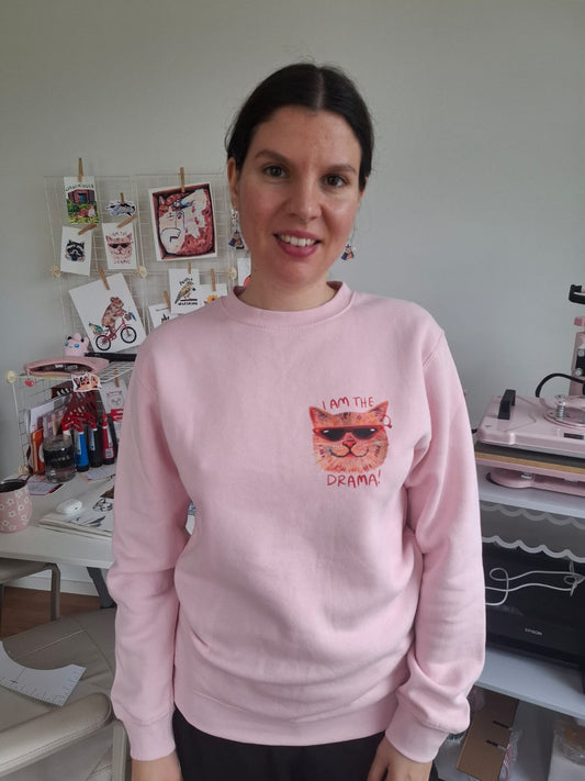 Baby pink eco-friendly sweater with “I Am the Drama Cat” design, made from organic cotton and recycled polyester.