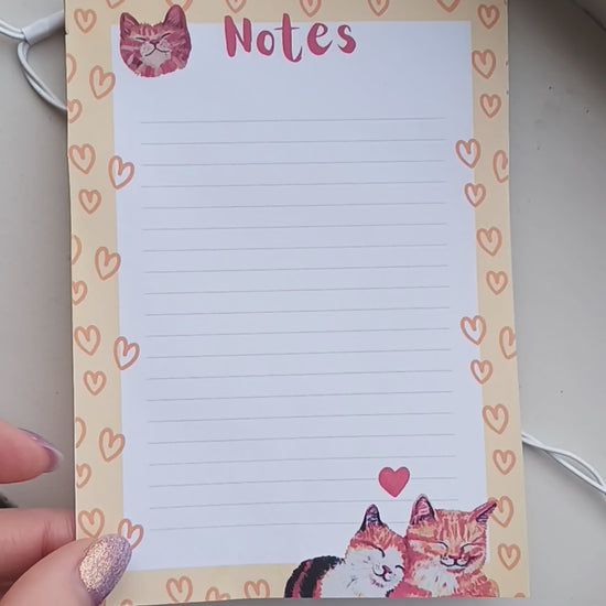 Cute notepad featuring two cats in love, warm yellow-orange colour, available in 30 or 50 pages, printed on eco-friendly paper with a sturdy cardboard back video